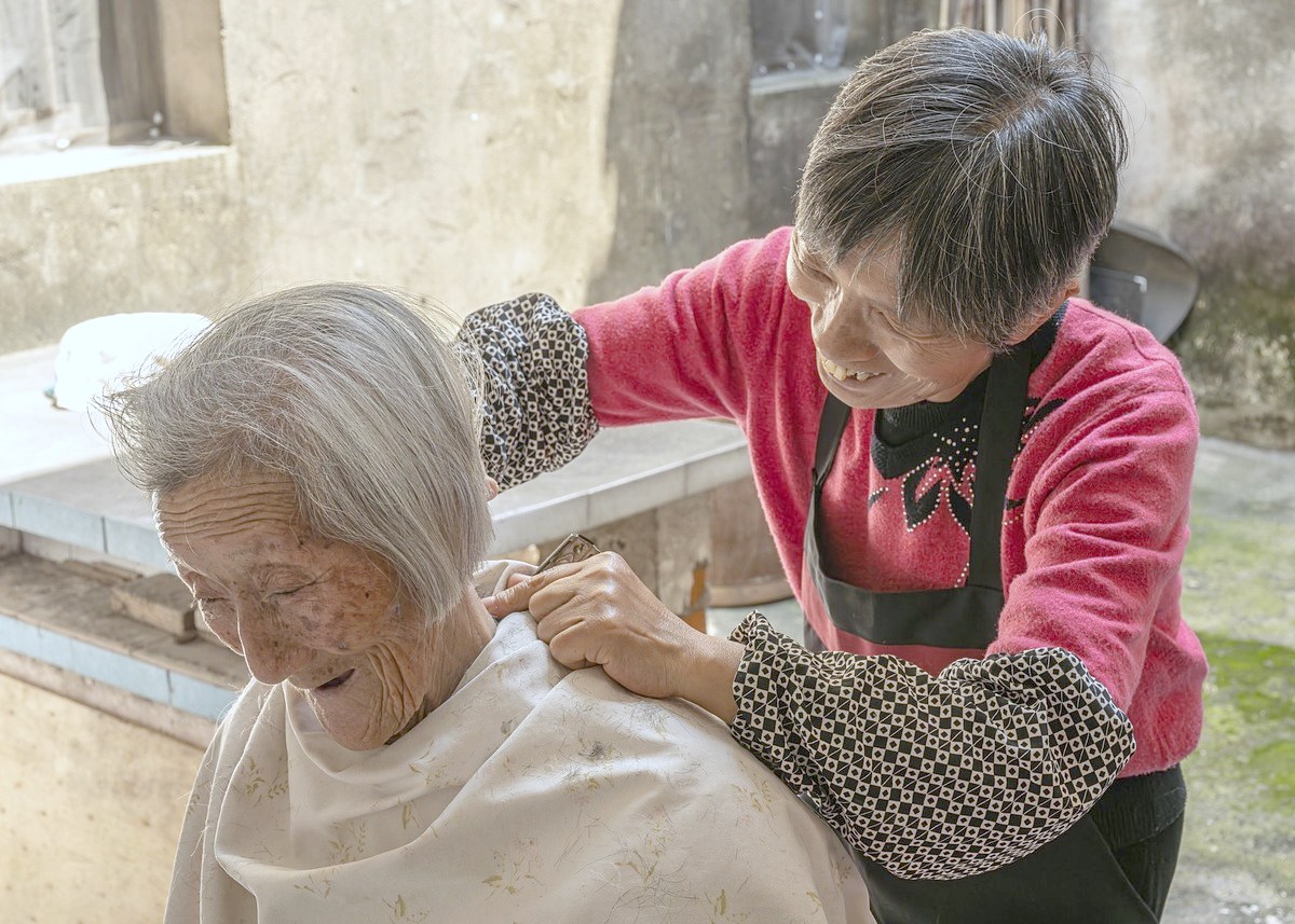 이미용 선생님이 어르신의 머리를 손질해 드리는 모습